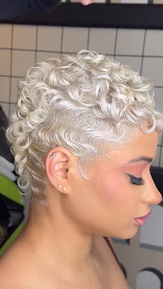 Curly blonde pixie cut with close-cropped sides and curled hair on top
