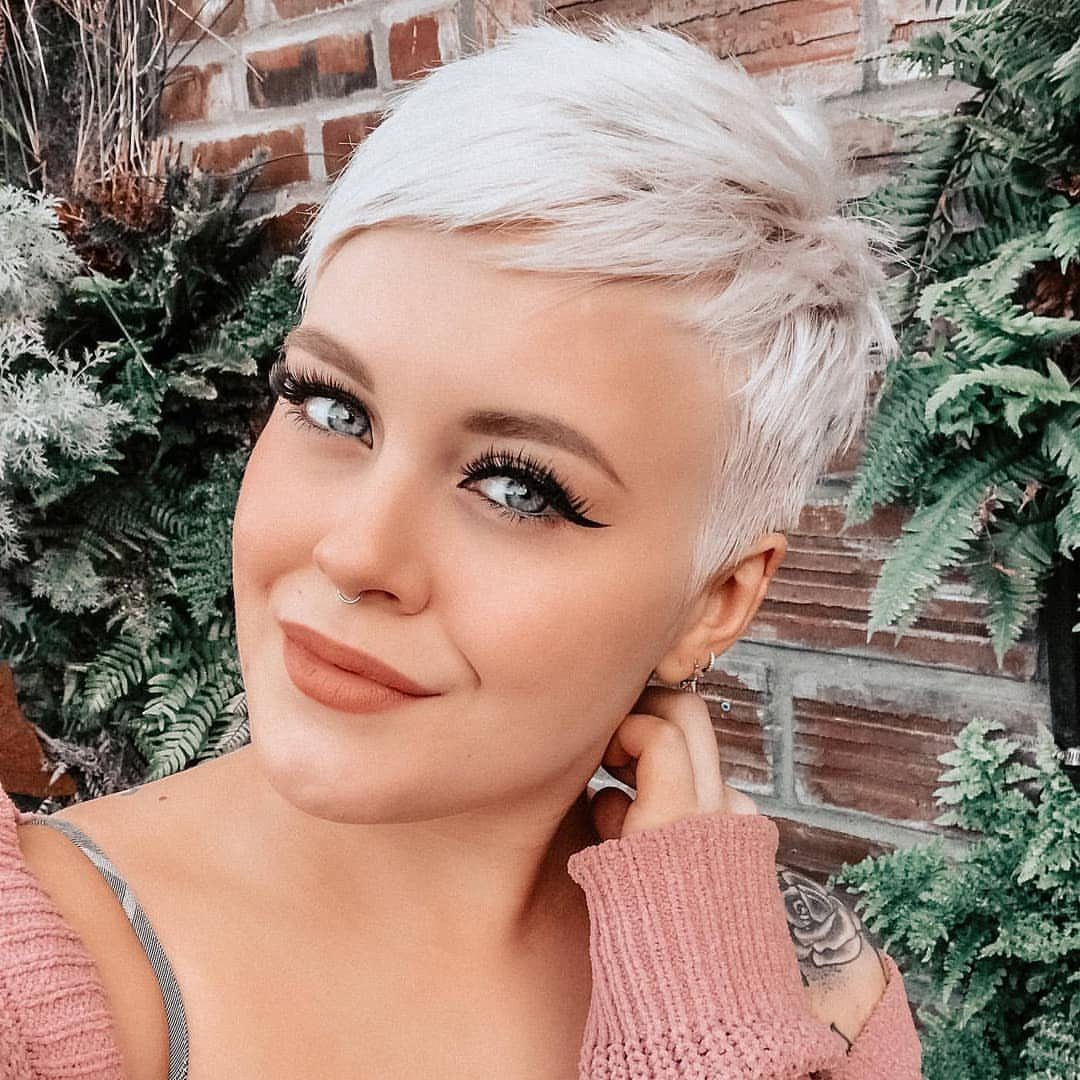 Woman with fluffy white-blonde pixie hair swept across her forehead