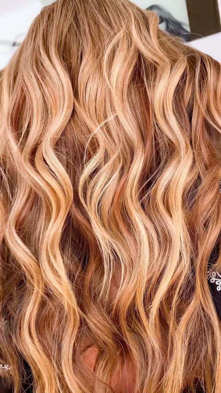Long wavy caramel strawberry blonde hair with golden highlights and reddish-brown tones