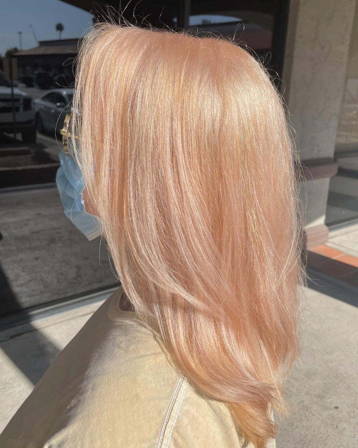 Long peachy strawberry-blonde hair falls smoothly over a person's shoulder