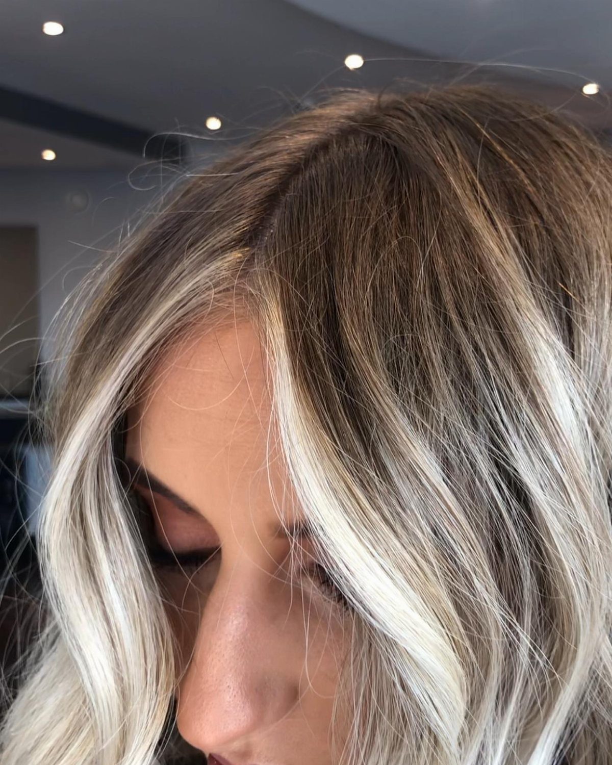 Bright blonde face-framing sections contrast with long dark brown hair