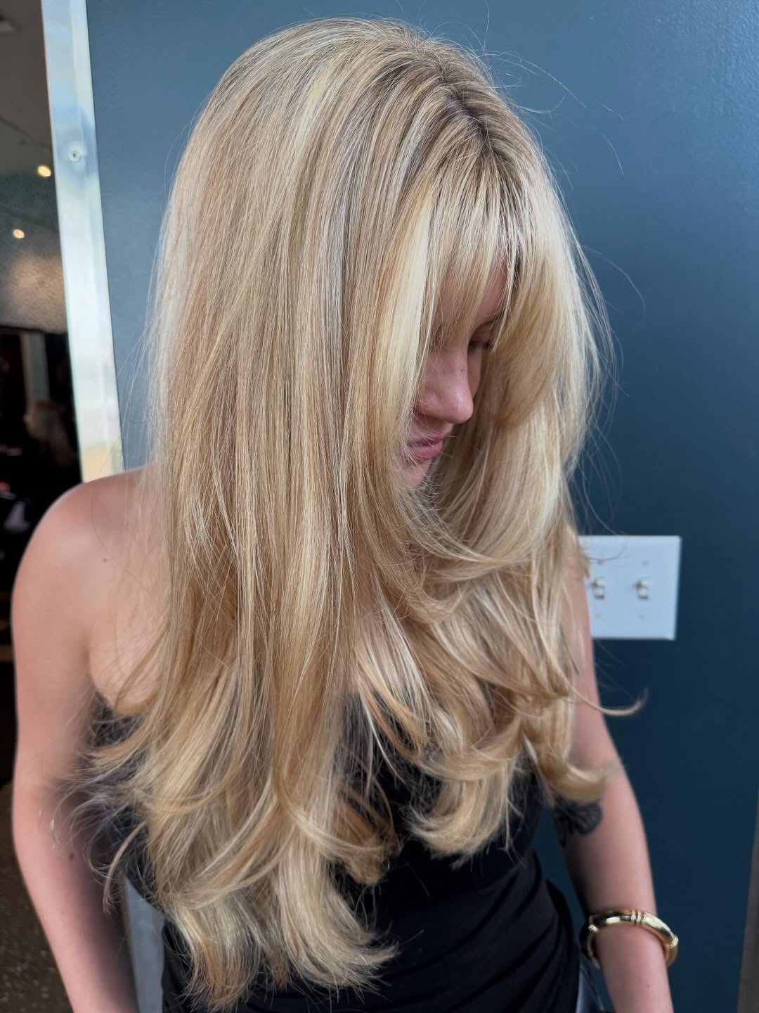 Woman showing long icy-white blonde hair with softly feathered, curled ends