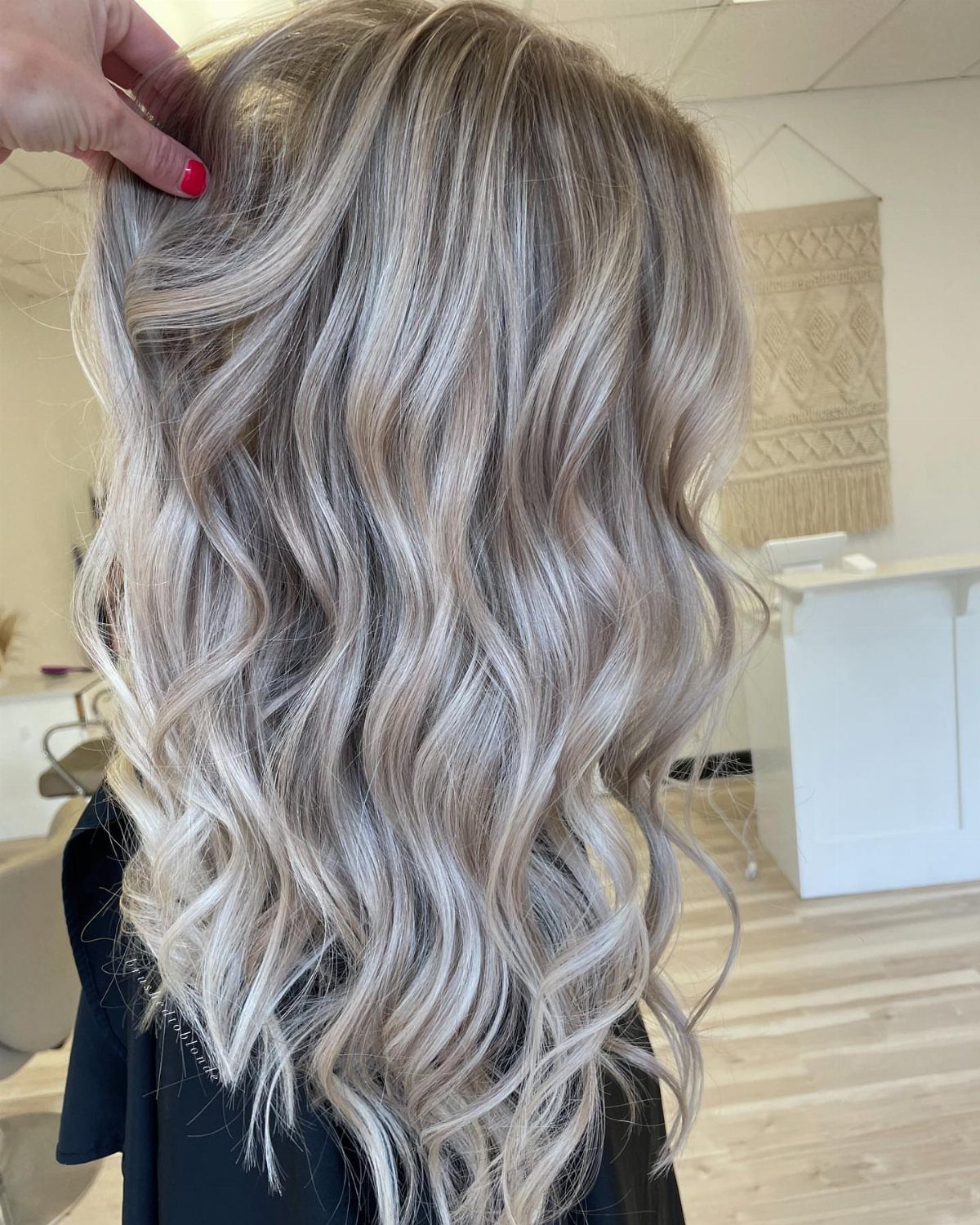 Shoulder-length waves show icy white-blonde highlights against darker roots