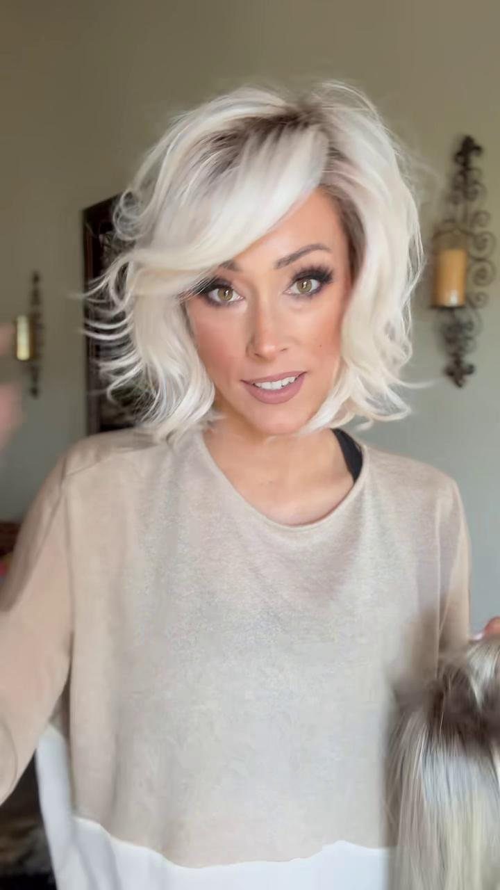 Woman with voluminous platinum-white hair swept across her forehead