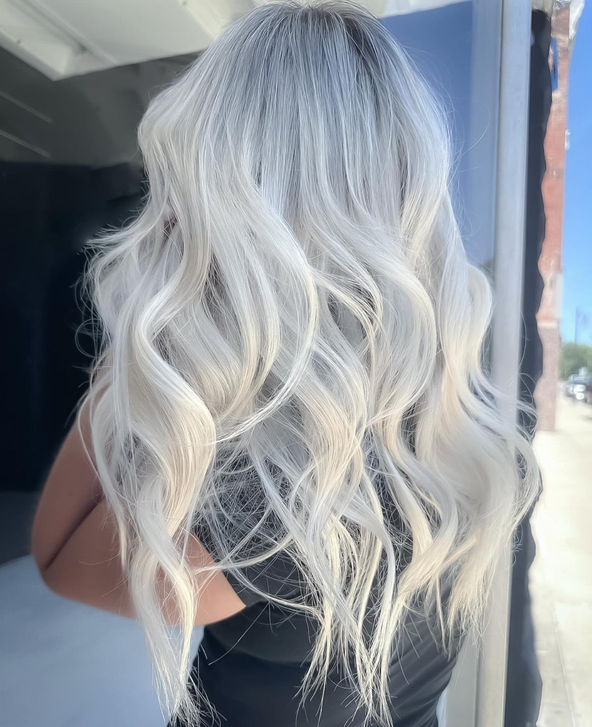 Long silver-white waves fade from darker gray roots to pale ends.