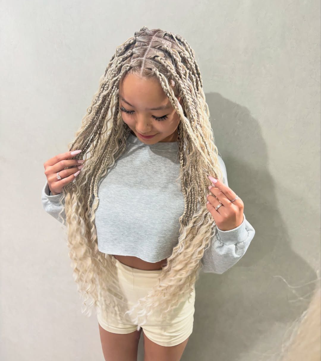 Person displaying extra-long pale blonde braids with loose wavy ends