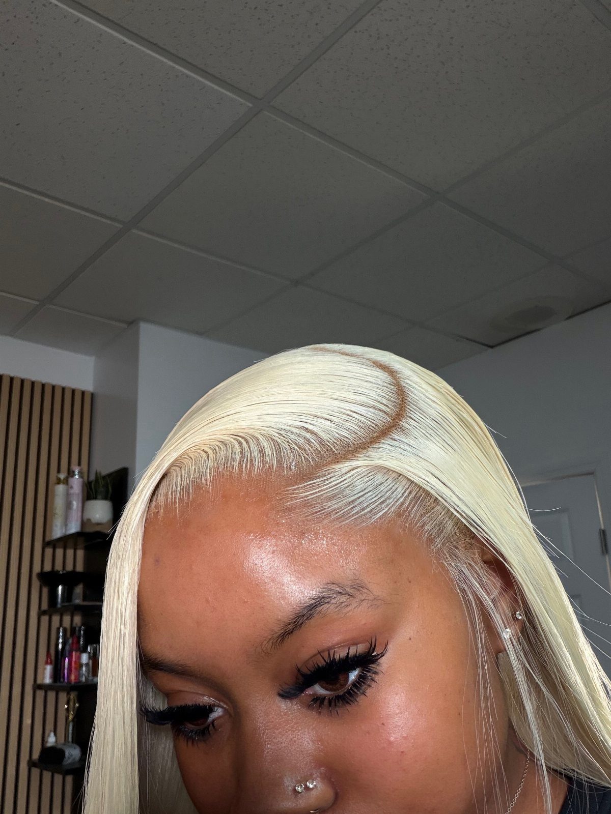 Person with long platinum blonde hair styled in a deep side part